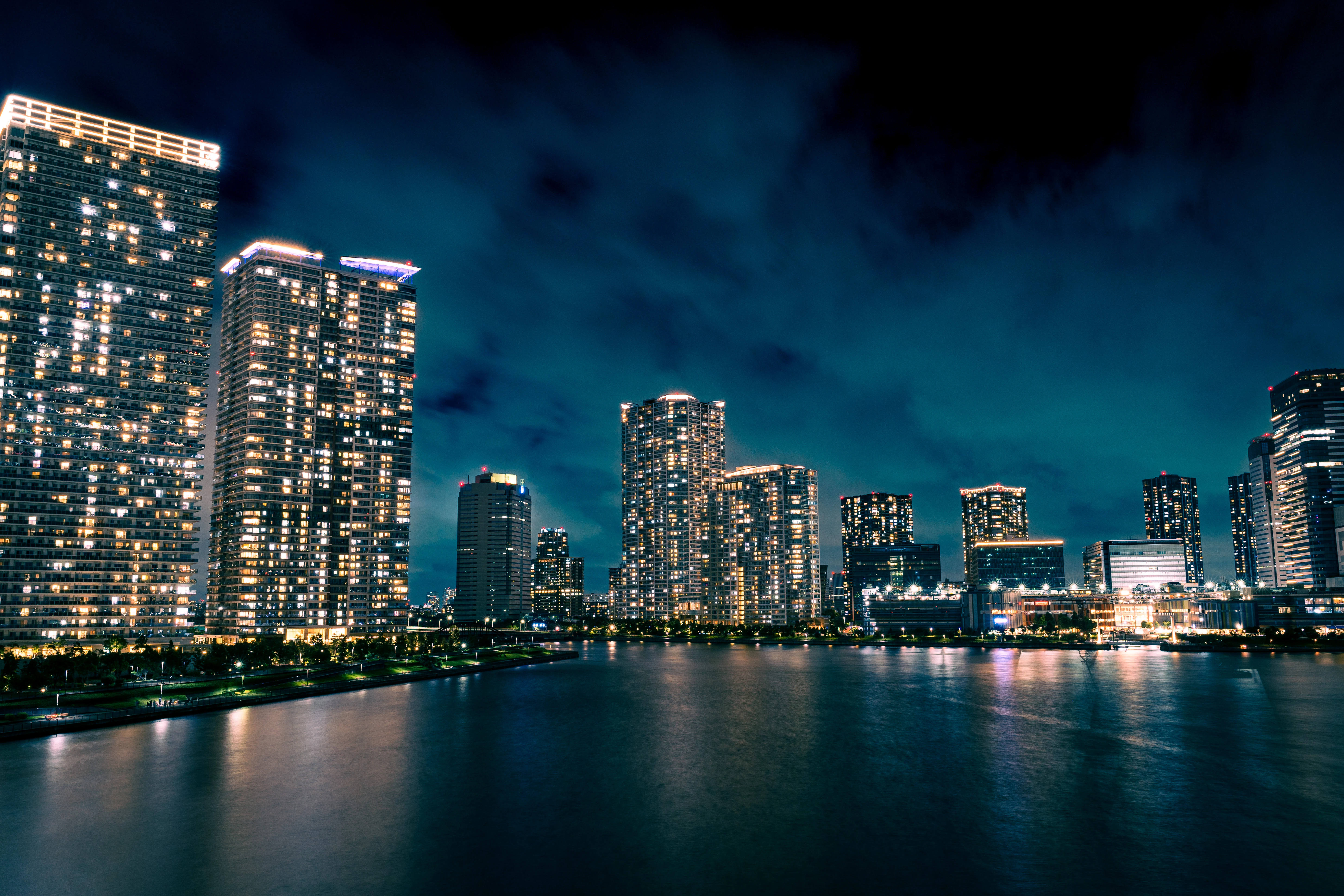 Luminous Skyscrapers Reflecting Over Tranquil Urban Waters